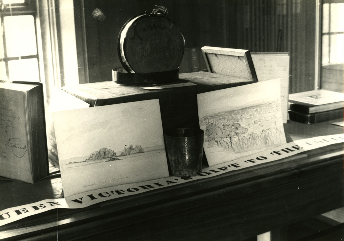 Sketches by Queen Victoria and her husband Prince Albert, placed on either side of a silver mug Victoria frequently used as a young princess, are seen on display at Victoria University in 1936. (Photo from Victoria University Archives)