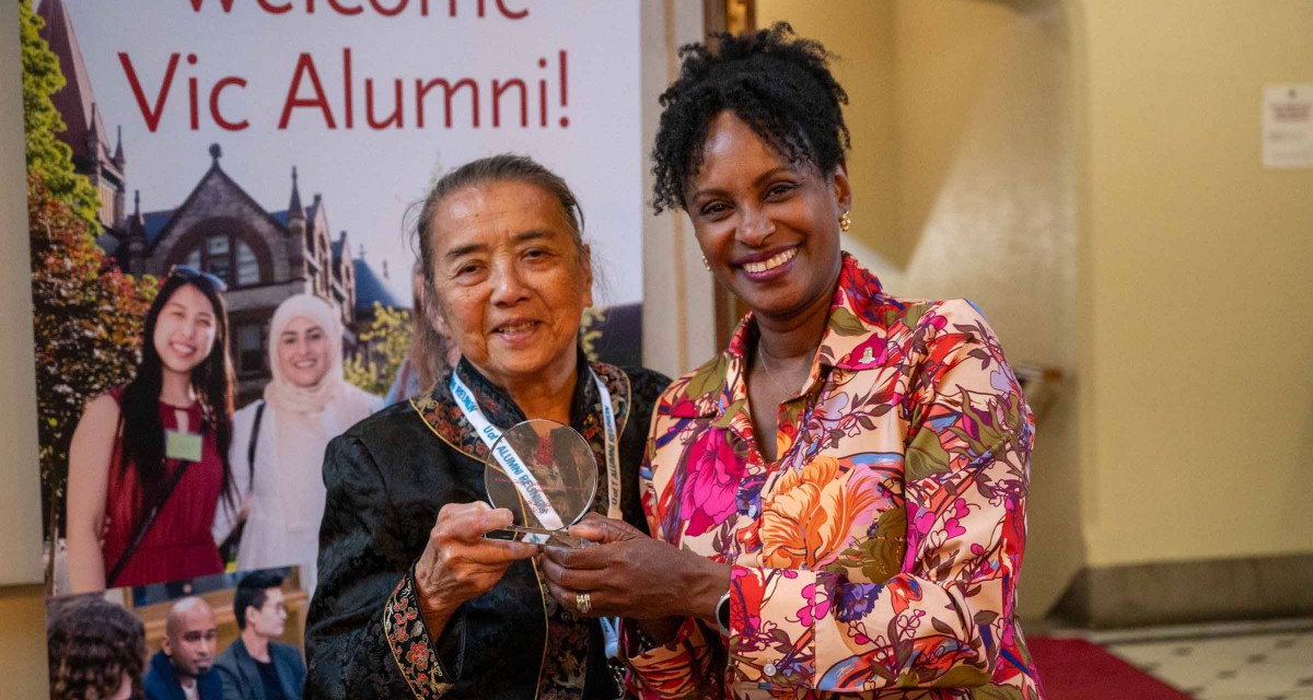Ruth Lor Malloy Vic 5T4 holds up her Distinguished Alumni Award with Vic U President Rhonda McEwen.