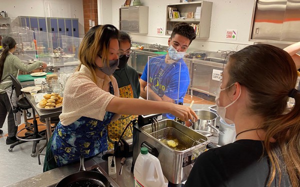 A group of students in a labratory mixing food and chemicals. 
